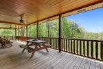 Main floor porch with a picnic table and rocking chairs